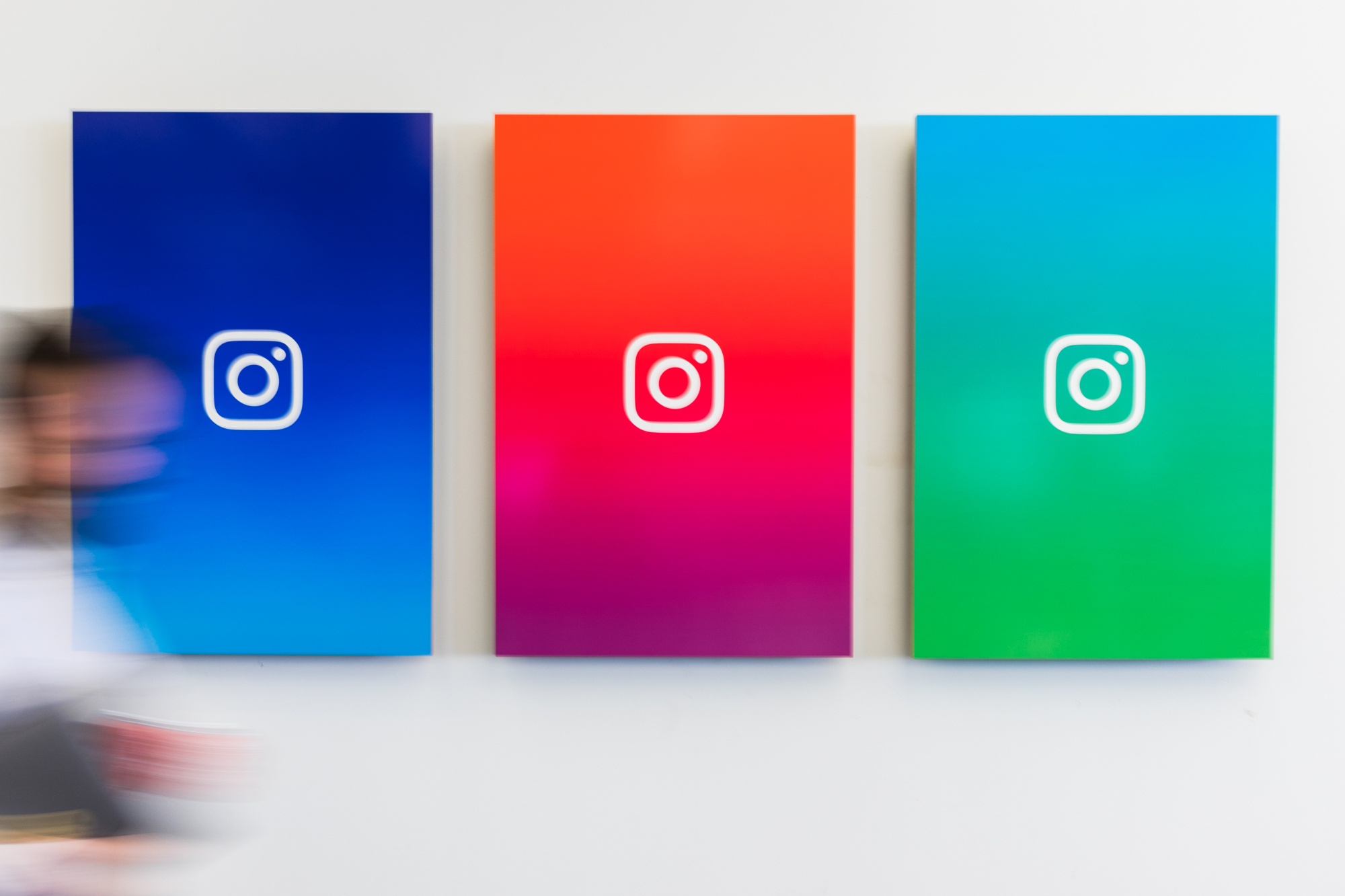 An employee walks past branded posters displayed at the Instagram Inc. office in New York, U.S., on Monday, June 4, 2018. Once, Instagram was a simple photo-sharing app, a way for iPhone shutterbugs to show off their latest cool pics. Now, its visual nature and 1 billion active users have sellers salivating over its potential as a place to sell everything from dresses to furniture. Photographer: Jeenah Moon/Bloomberg