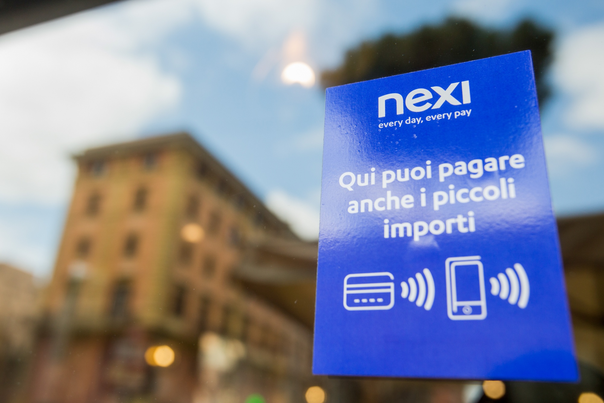 A sign at the entrance to a restaurant shows that payment services are provided by Nexi SpA in Rome, Italy. Photographer: Giulio Napolitano/Bloomberg