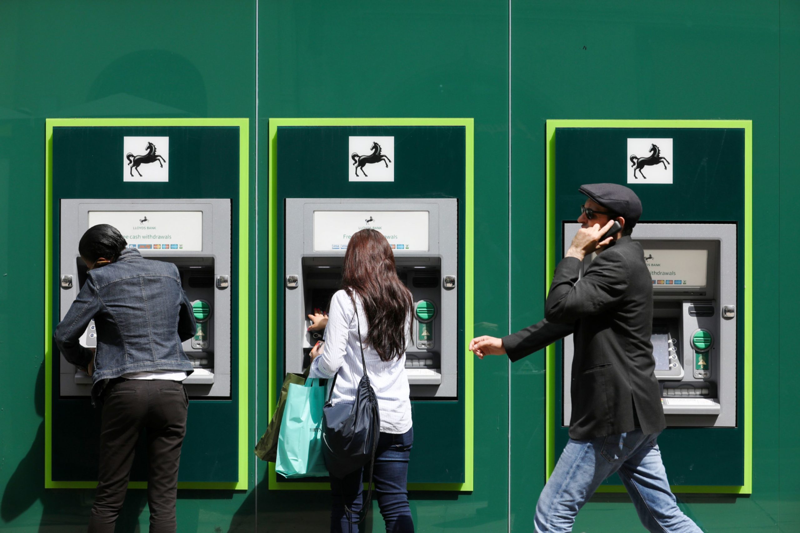 People use ATMs outside a Lloyds Bank branch in London, U.K., on Wednesday, May 31, 2017. Luke MacGregor/Bloomberg