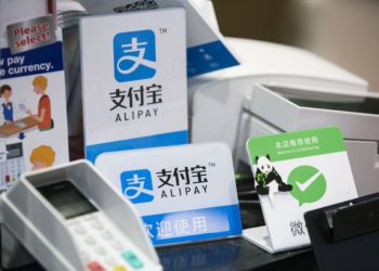 Signs for Ant Financial Services Group's Alipay, an affiliate of Alibaba Group Holding Ltd., center top and center bottom, and Tencent Holdings Ltd.'s WeChat Pay, right, are displayed at a Takeya Co. Ueno Select shop in Tokyo, Japan, on Saturday, Dec. 9, 2017. Ant Financial and its strategic partners outside China should be able to nearly double users of their payments systems in coming years, Ant's overseas operations president Douglas Feagin said on Nov. 14. Photographer: Shiho Fukada/Bloomberg