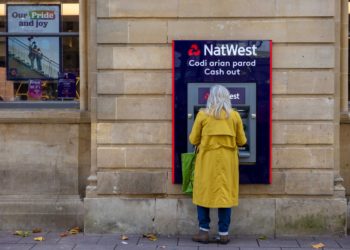 A woman uses an automated teller machine (ATM) at a bank branch of Natwest Group Plc on Queen Street in Cardiff, UK, on Friday, Oct. 28, 2022. UK inflation could soar to 15% or more early next year unless the government sets out further measures to protect households from a jump in energy bills, economists said. Photographer: Hollie Adams/Bloomberg