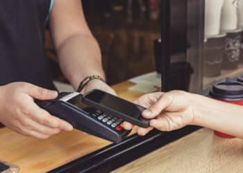 A person uses a digital card to complete a transaction.