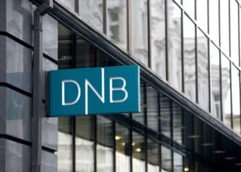 A DNB logo sits on display outside a DNB ASA bank branch in Vilnius, Lithuania, on Monday, Dec. 15, 2014. Lithuania will switch currencies to the euro on Jan. 1, 2015. Photographer: Peter Kollanyi/Bloomberg