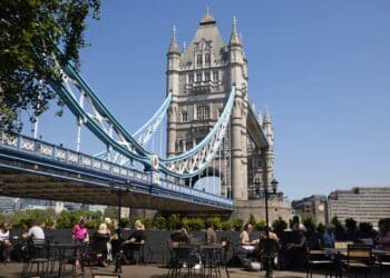 Visitors sit at restaurant tables against a backdrop of Tower Bridge in London, UK, on Saturday, June 10, 2023. Soaring temperatures caused by a blast of hot air led the UK to post fresh health warnings through the weekend. Photographer: Chris Ratcliffe/Bloomberg
