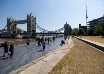 Visitors pass pass along the embankment near Tower Bridge in London, UK, on Saturday, June 10, 2023. Soaring temperatures caused by a blast of hot air led the UK to post fresh health warnings through the weekend. Photographer: Chris Ratcliffe/Bloomberg