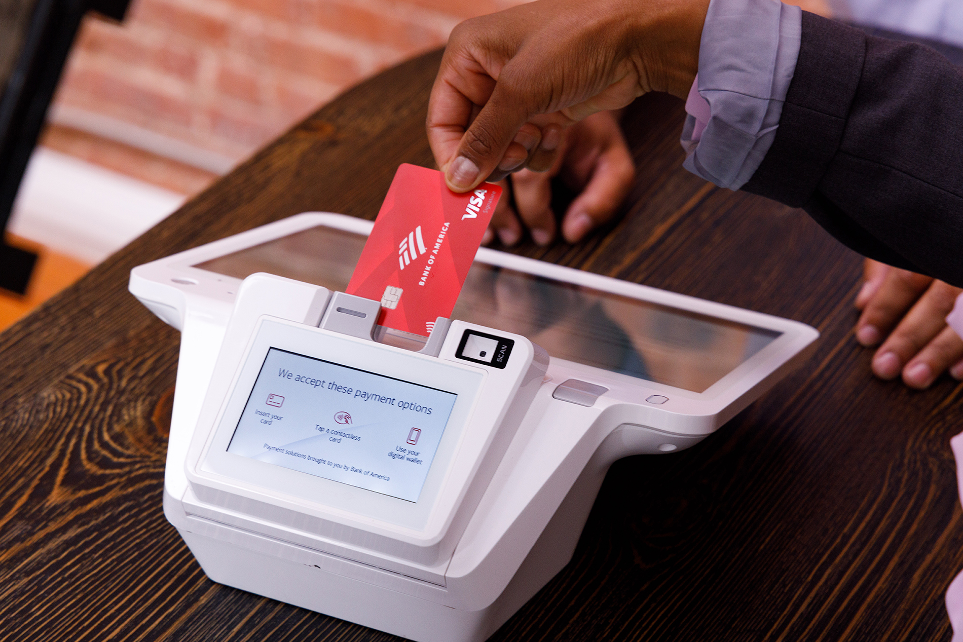 Person making a purchase with debit card by inserting it into the card terminal. Courtesy/Bank of America